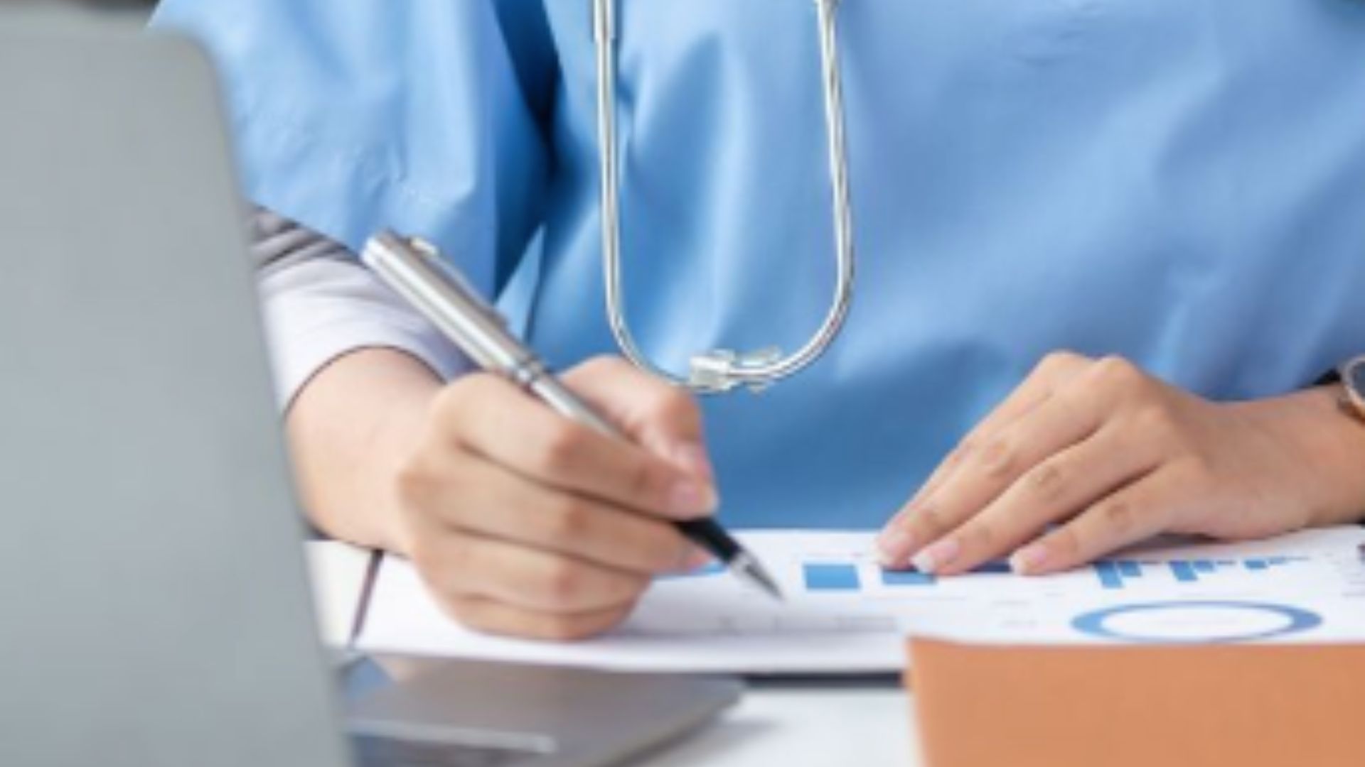 doctor writing on a patient chart