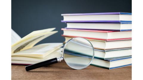 Books and a magnifying glass on a desk