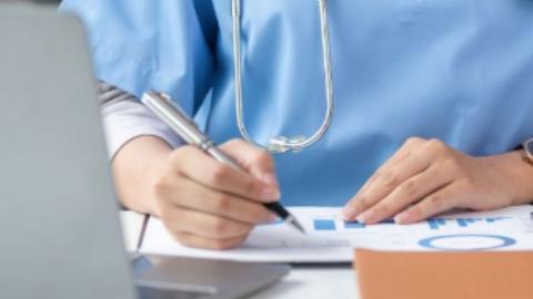 doctor writing on a patient chart